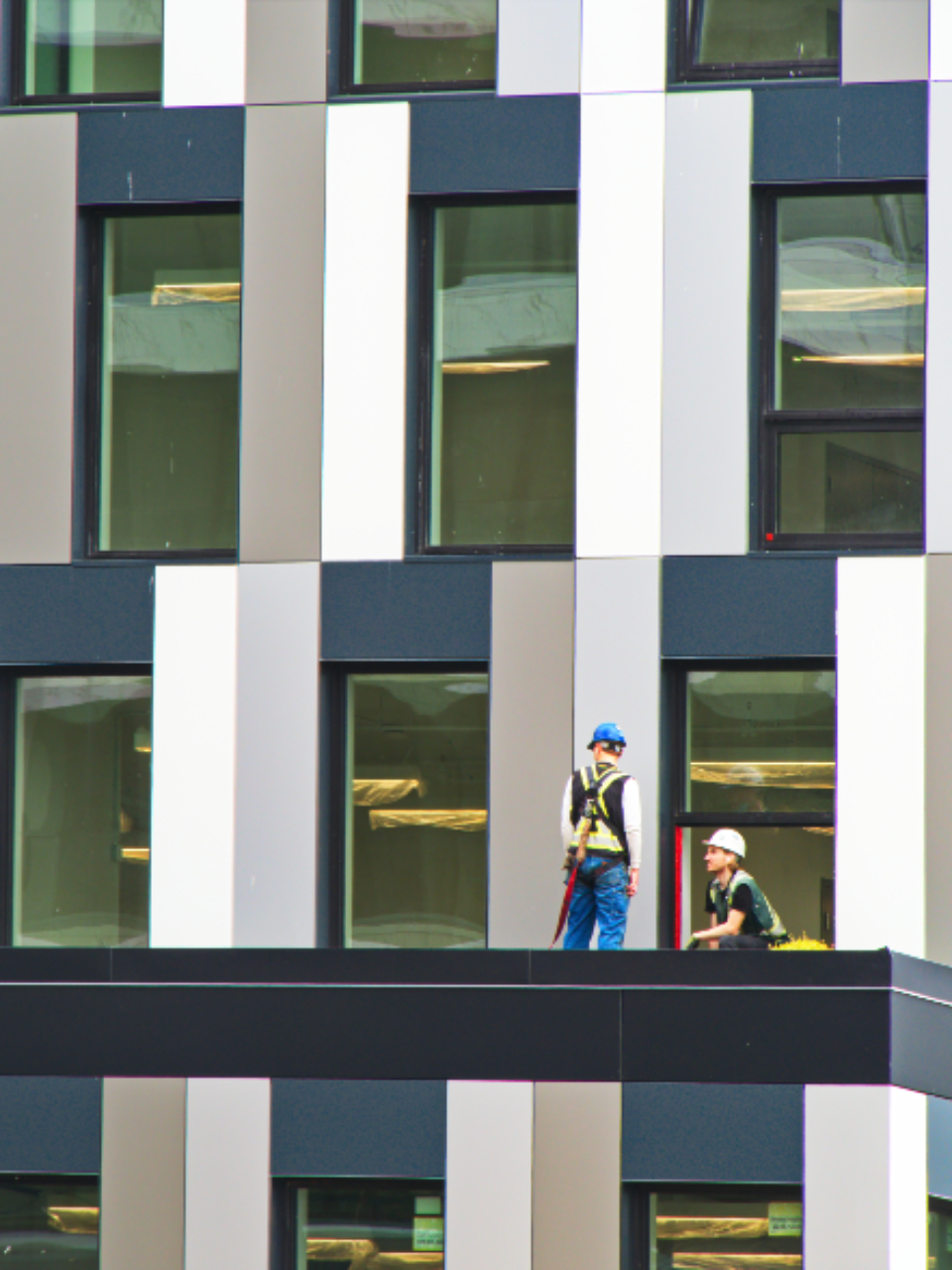 Construction workers in hard hats on a building under construction.